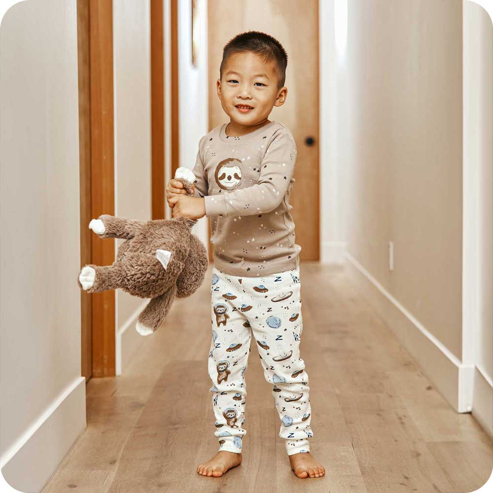 Image 87: Child playing with Plush Warmies Stuffed Animal while wearing Sloth Pajamas - Warmies USA