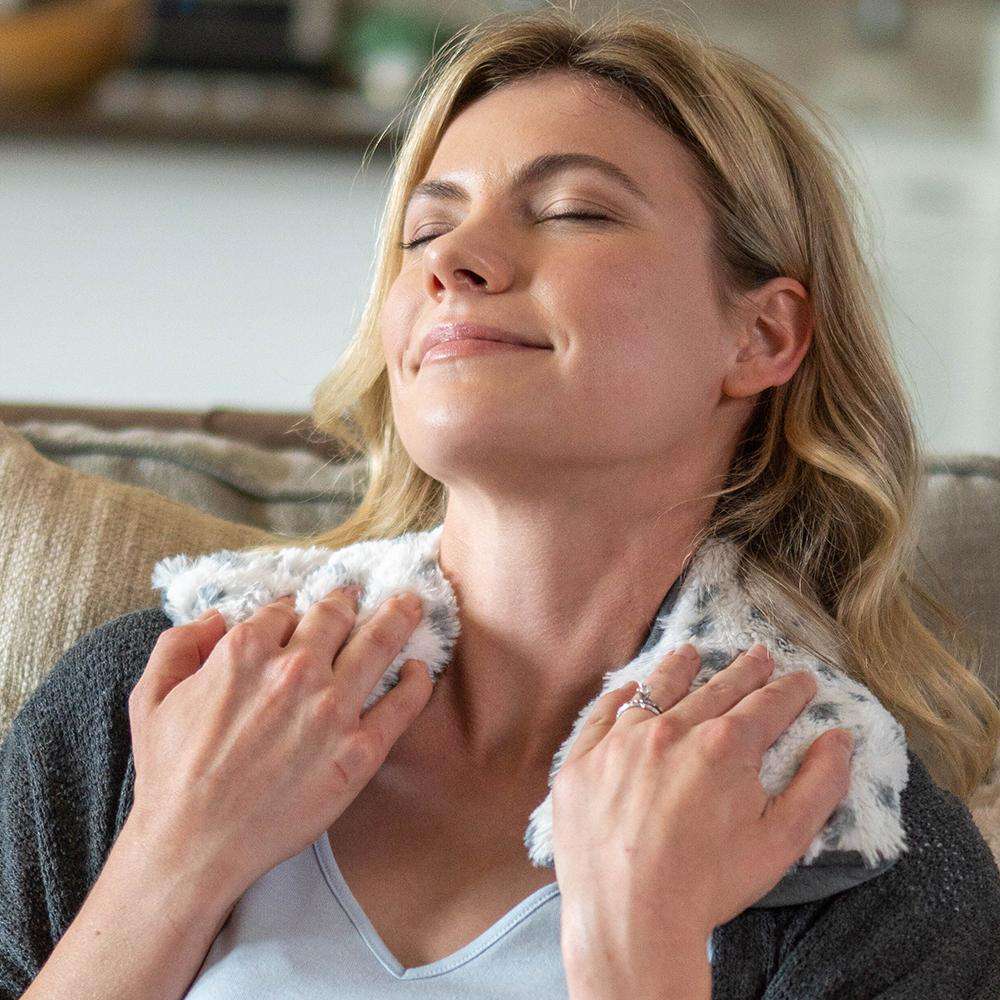 Image 91: Adult relaxing with Cozy Microwavable Snowy Warmies Neck Wrap.