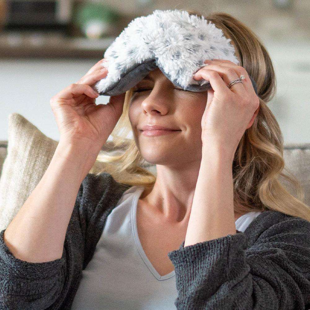 Image 91: Woman wearing Snowy Warmies Eye Mask: Microwavable bliss for serene relaxation.
