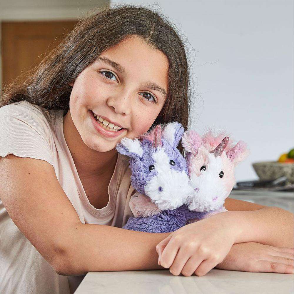 Image 97: Girl smiling while hugging Heated Unicorn Hugs Plush Warmies
