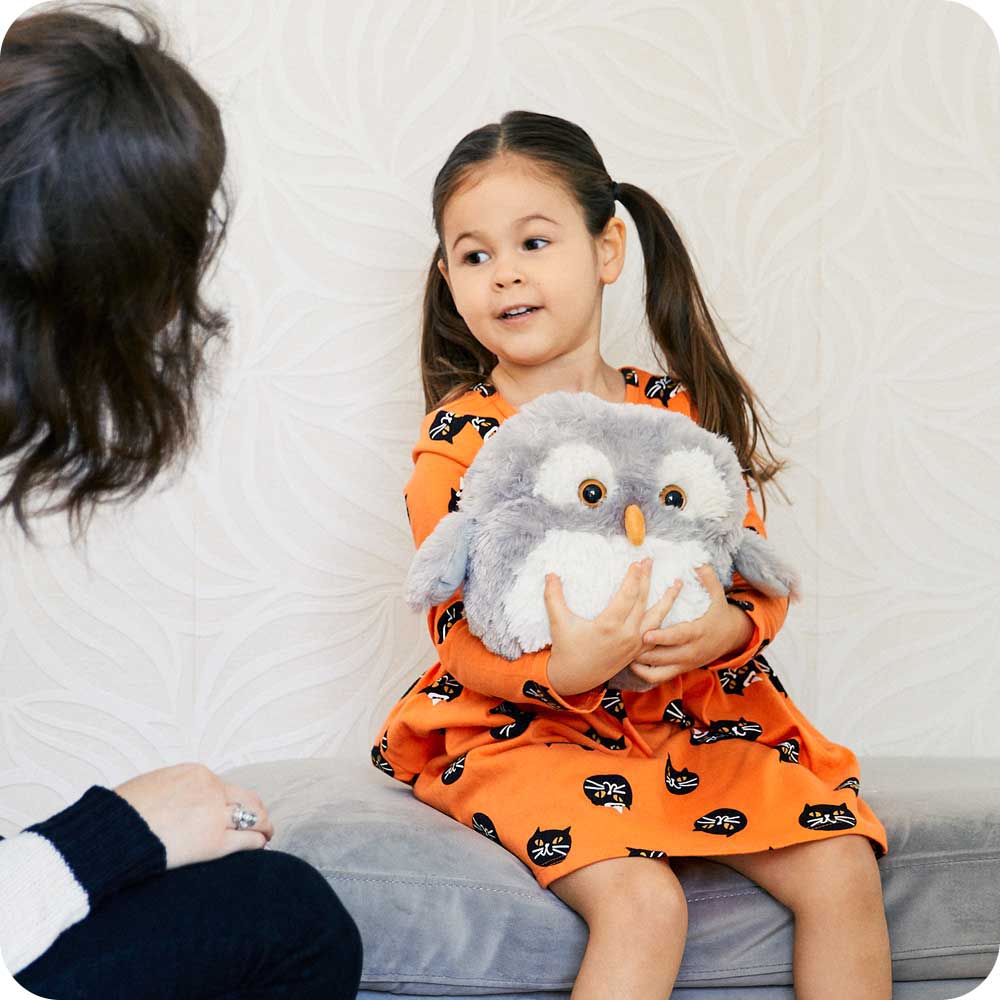 Image 96: Child hugging a Soft Warm Weighted Owl Plush Warmies